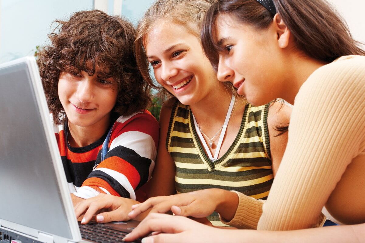 Drei Jugendliche vor einem Laptop