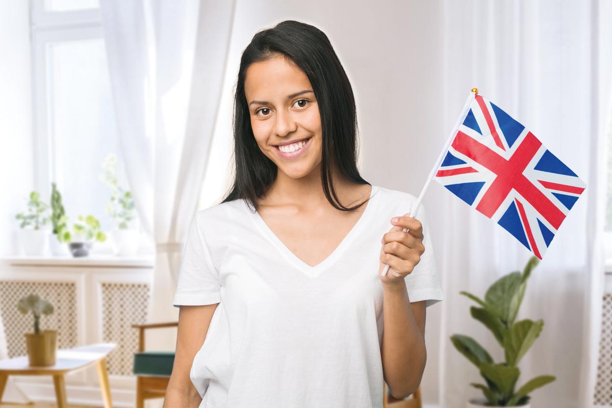 Eine Frau mit einer englischen Flagge lächelt in die Kamera